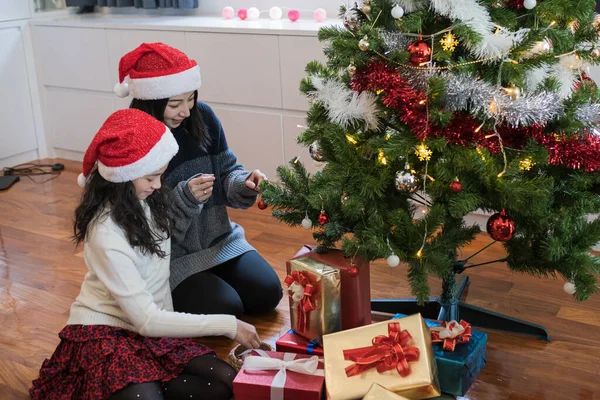 Famiglia felice, madre e figlia aiutano a decorare regalo, giocattolo, p — Foto Stock