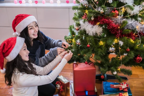 Famiglia felice, madre e figlia aiutano a decorare regalo, giocattolo, p — Foto Stock