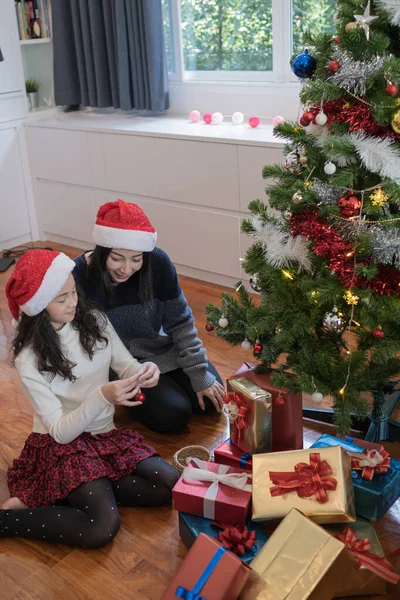 Famiglia felice, madre e figlia aiutano a decorare regalo, giocattolo, p — Foto Stock