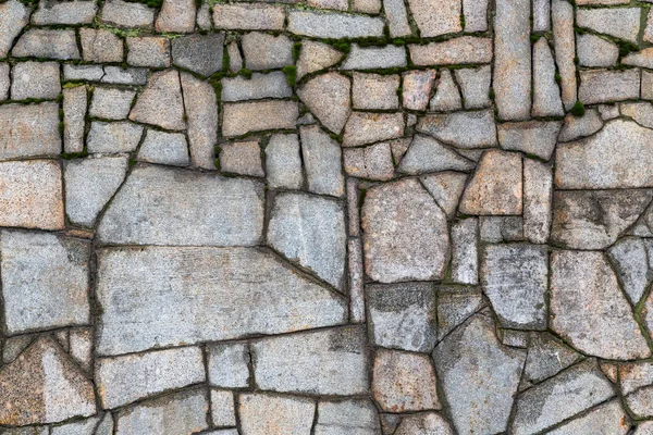Parede de pedra texturizada com rachaduras e musgo — Fotografia de Stock