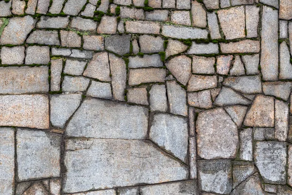 Parede de pedra texturizada com rachaduras e musgo — Fotografia de Stock