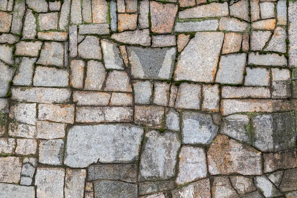 Parede de pedra texturizada com rachaduras e musgo — Fotografia de Stock