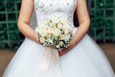 Bir buket çiçek onun elinde tutan gelin