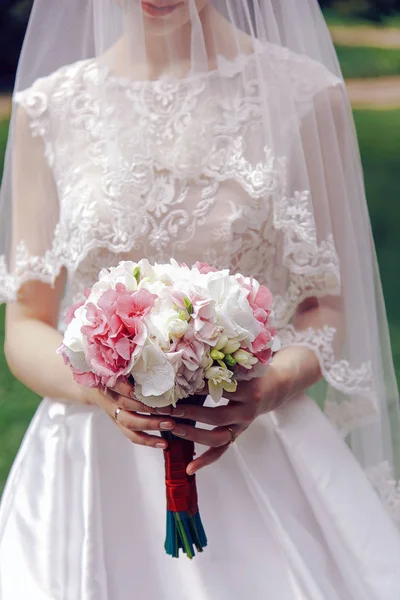 Mariée tenant un bouquet de fleurs dans sa main — Photo