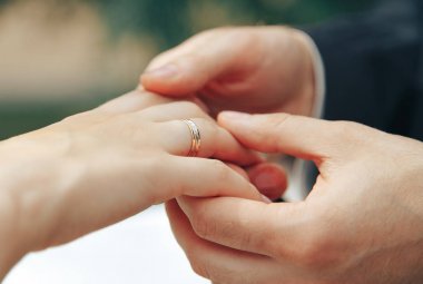 Damat gelinin elini tutar.