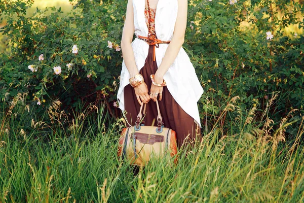 Uma garota hippie segurando um saco contra um fundo da natureza — Fotografia de Stock