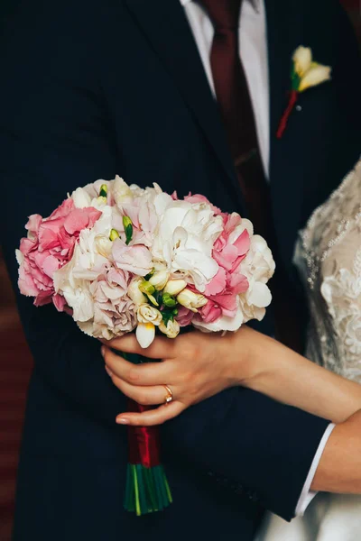 A noiva mantém seu buquê de casamento — Fotografia de Stock