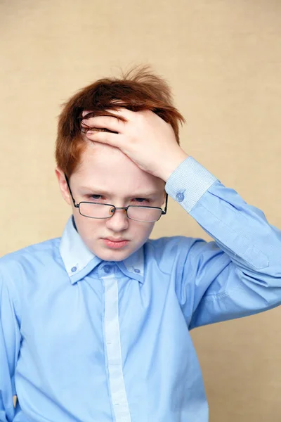 Redhead boy holding his head — Stock Photo, Image