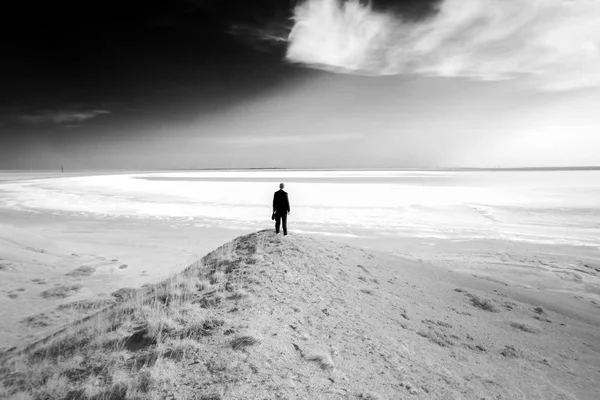 Schwarz-Weiß-Foto einer Silhouette eines Mannes auf dem Hintergrund eines Salzsees — Stockfoto