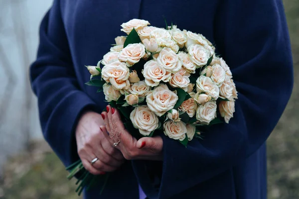 Uma mulher segurando um buquê de flores brancas — Fotografia de Stock