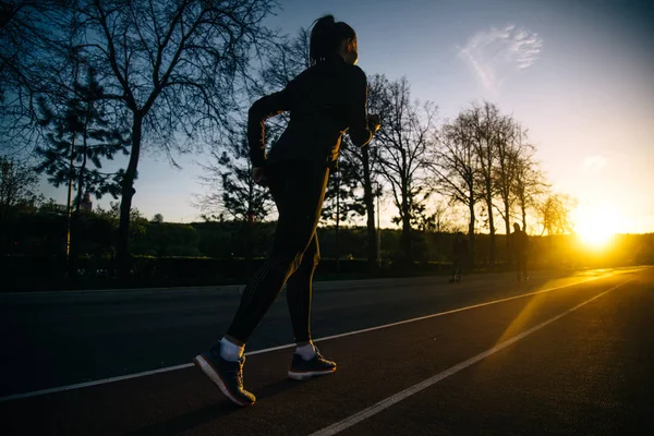 Meisje uitgevoerd en opleiding bij zonsondergang — Stockfoto