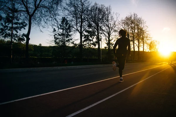 Meisje uitgevoerd en opleiding bij zonsondergang — Stockfoto