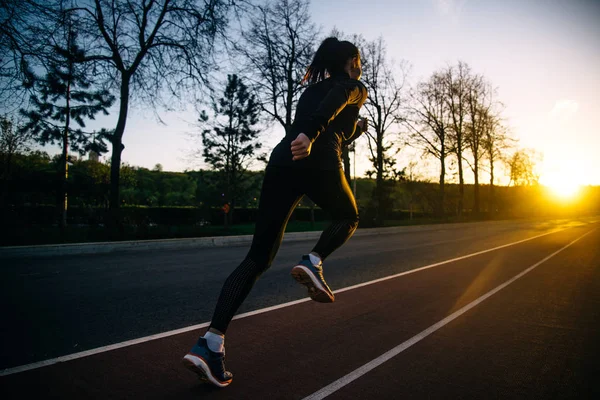 Meisje uitgevoerd en opleiding bij zonsondergang — Stockfoto