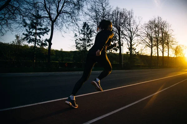 Meisje uitgevoerd en opleiding bij zonsondergang — Stockfoto