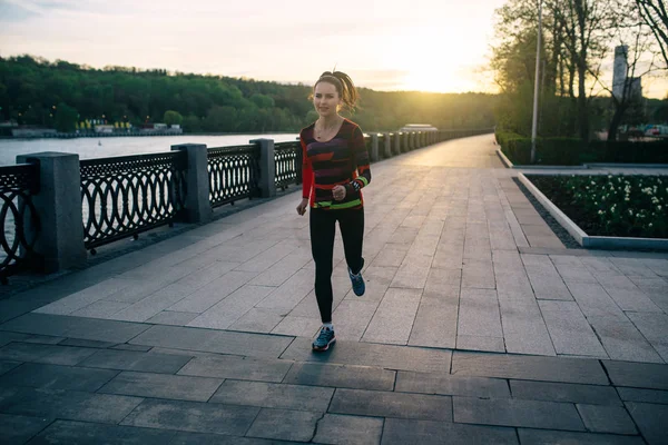 Dívka běh a školení při západu slunce — Stock fotografie