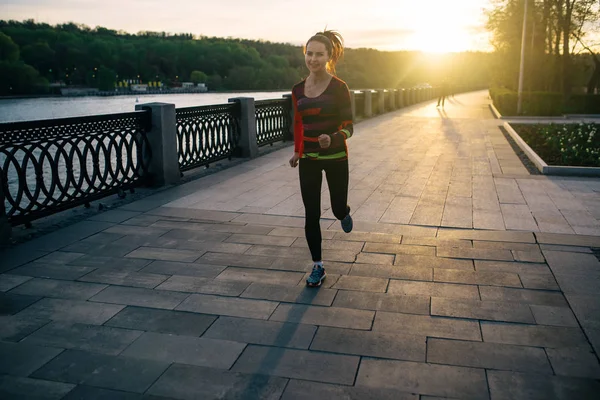 Meisje uitgevoerd en opleiding bij zonsondergang — Stockfoto