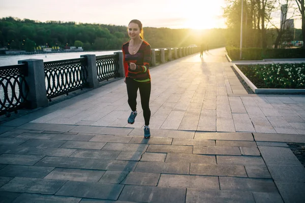 Meisje uitgevoerd en opleiding bij zonsondergang — Stockfoto