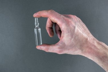 Ampulün ışık gri arka plan üzerinde bir el