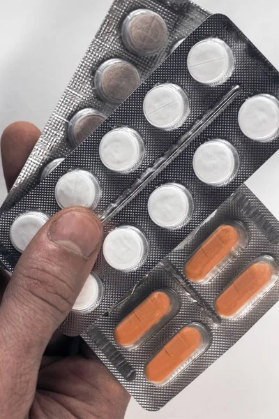 Medicamentos de mano: prospecto de plata lleno de pastillas blancas en forma de tabletas comunes, aisladas sobre fondo blanco — Foto de Stock