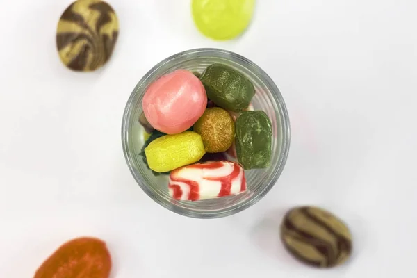 Барвисті цукерки в скляній мисці ізольовані на білому — стокове фото