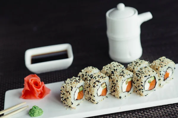 Rolos tradicionais de sushi japonês fresco em uma placa branca — Fotografia de Stock