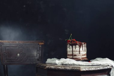 Bir masada kırmızı kuş üzümü ile çikolatalı kek