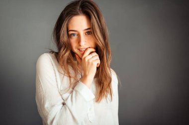 Gri arka planda beyaz gömlekli genç bir kız. Gri duvarların arkasında beyaz bluzlu bir Fransız kadın. Rötuş yapmadan.