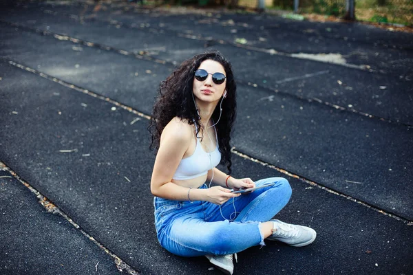 Uma Jovem Morena Com Óculos Com Cabelos Longos Encaracolados Senta — Fotografia de Stock