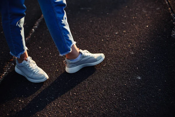 行くべき道を決めなさい 歩きゴム製の道 ジーンズとグレーのスニーカーの女性の足 地面の上の足の影 — ストック写真