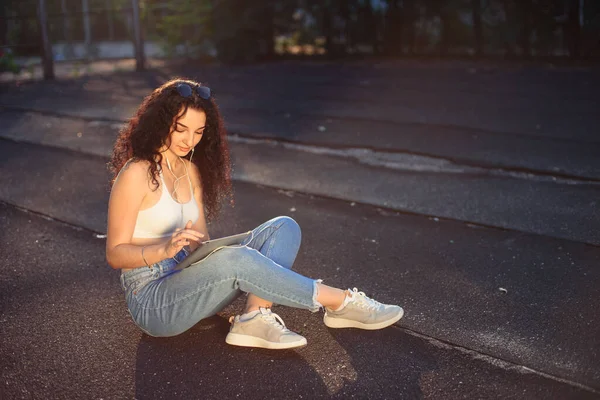 Young Brunette Glasses Long Curly Hair Sits Ground Street White — Stock Photo, Image