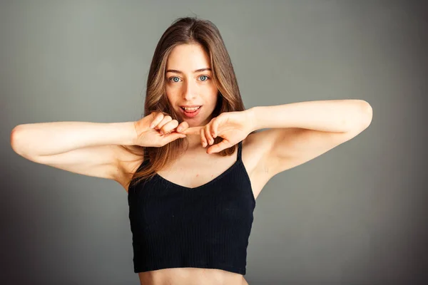 Dívka Černém Svršku Vlasy Oběma Rukama Pod Bradou Šedém Pozadí — Stock fotografie