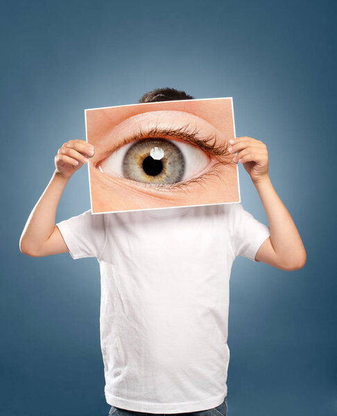 kid holding a picture of an eye watching