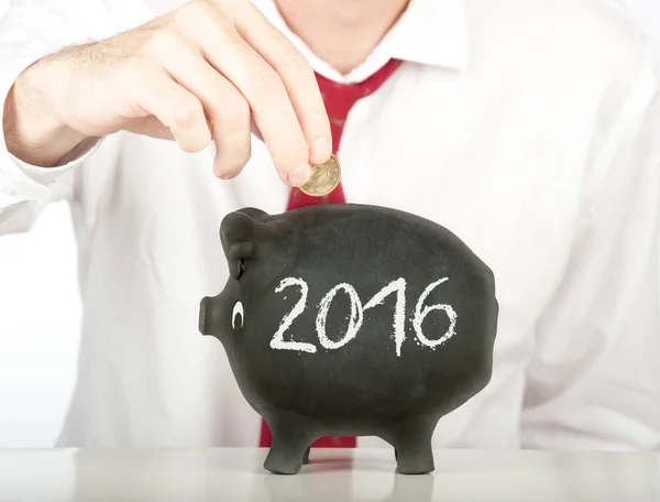 Putting money on a piggy bank — Stock Photo, Image