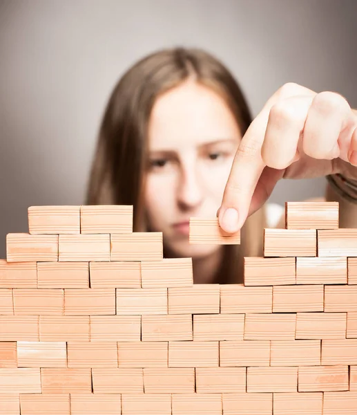 Young woman building a wall — Stock Photo, Image