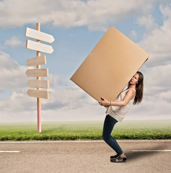Mujer joven sosteniendo una caja de cartón — Foto de Stock