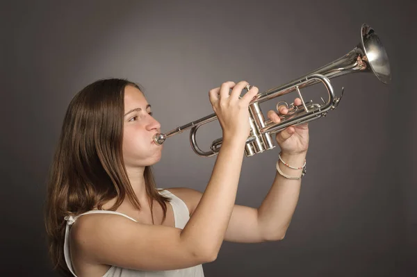 Fiatal nő játszik trombita — Stock Fotó