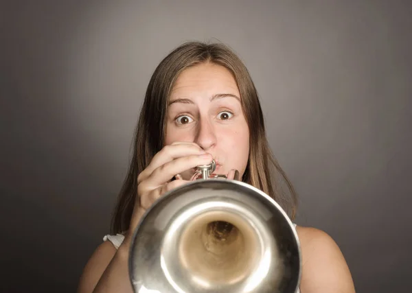 Jovem mulher tocando trompete — Fotografia de Stock