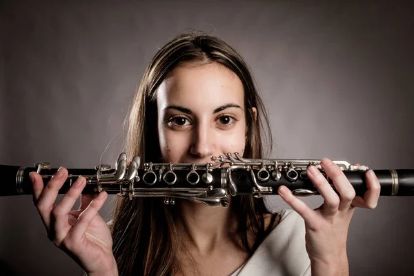 Mujer Joven Sosteniendo Clarinete Sobre Fondo Gris —  Fotos de Stock