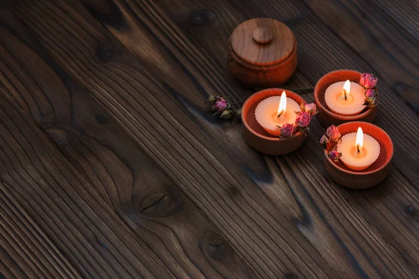 Melocotón velas pequeñas en copas de madera con flores secas — Foto de Stock