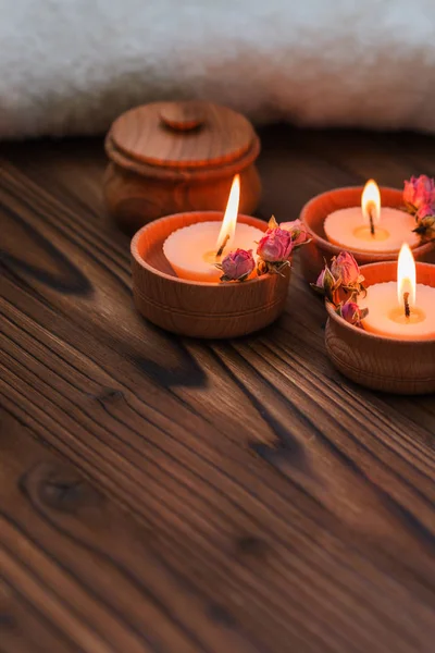 Персиковые свечи в деревянных чашках с сушеными цветами — стоковое фото