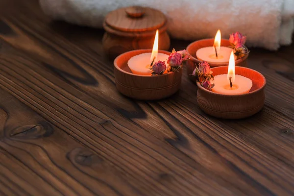 Pêcher les petites bougies dans des tasses en bois avec des fleurs séchées — Photo