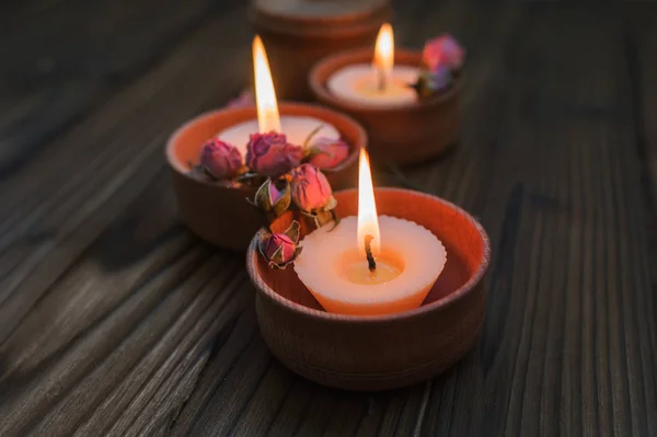 Pêssego pequenas velas em copos de madeira com flores secas — Fotografia de Stock