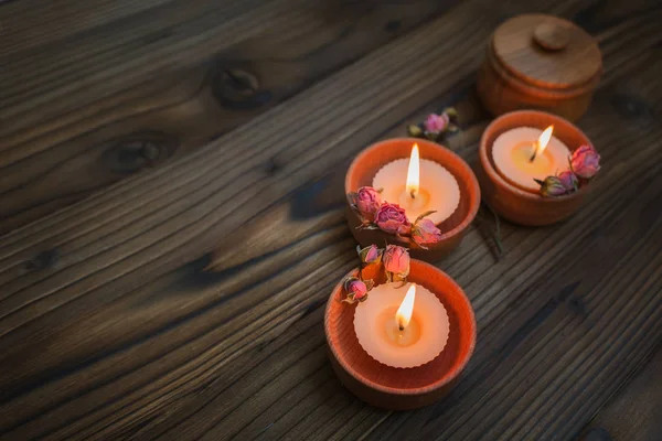 Pêssego pequenas velas em copos de madeira com flores secas — Fotografia de Stock