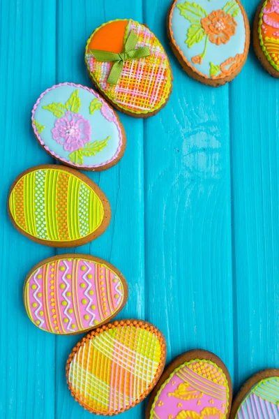 Hausgemachte Plätzchen mit Zuckerguss in Form eines Ostereiers. leckere Osterkekse auf blauem Hintergrund. Plätzchen für Frühlingsstimmung. Farbige Eier auf blauem Hintergrund. — Stockfoto