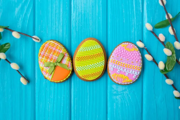 Galletas caseras con glaseado en forma de huevo para Pascua. Deliciosas galletas de Pascua sobre un fondo azul. Galletas para el estado de ánimo primavera. Huevos de colores sobre fondo azul . — Foto de Stock