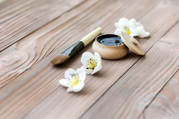 Black substance in wooden jar on a wooden background. Black Mask — Stock Photo, Image