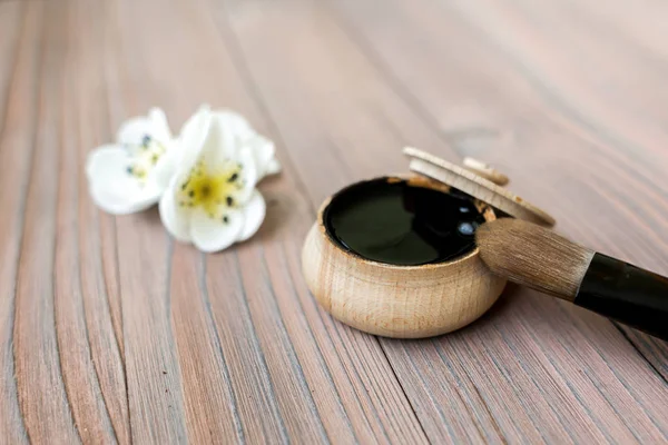 Black substance in wooden jar on a wooden background. Black Mask — Stock Photo, Image