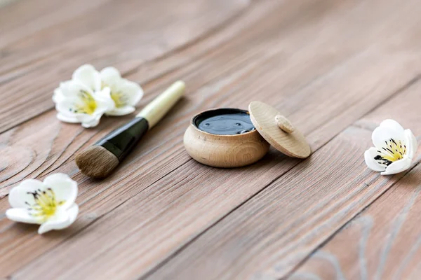 Black substance in wooden jar on a wooden background. Black Mask — Stock Photo, Image