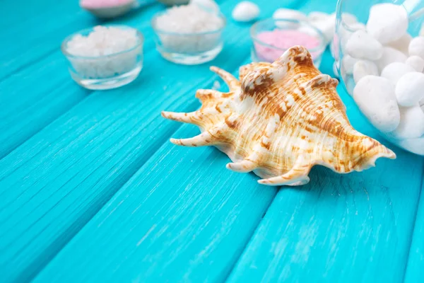  spa ve rahatlama mavi bir arka plan üzerinde deniz tuzu bir bardak beyaz taşlar ve kabuk