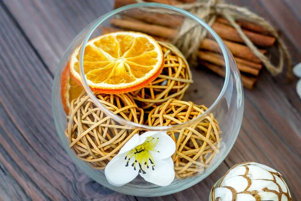 Декоративные шарики и сушеный апельсин в стеклянный шар с корицей с различными красивыми предметами . — стоковое фото